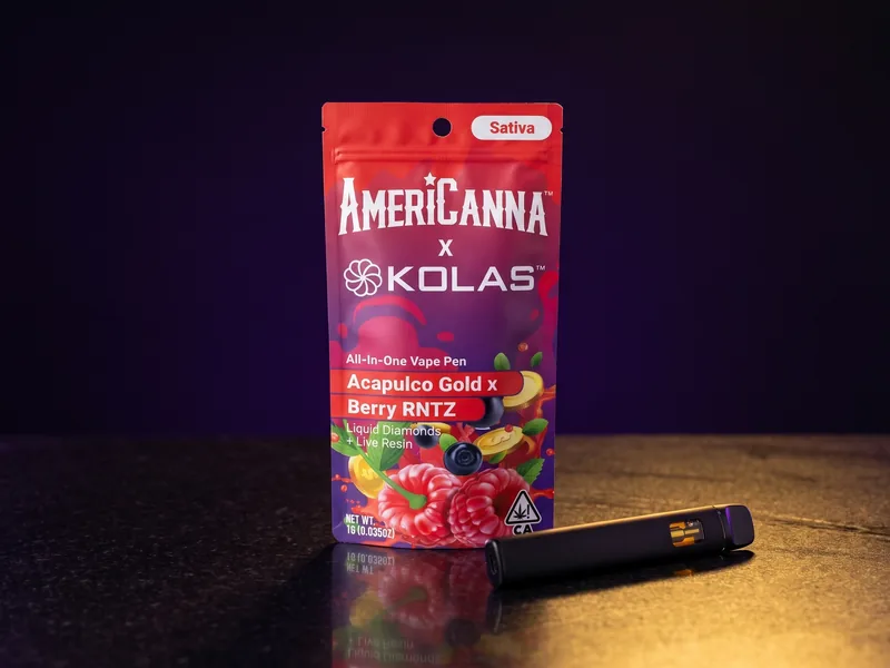 An AmeriCanna x KOLAS Sativa all-in-one vape pouch, Acapulco Gold x Berry RNTZ, with the KOLAS pinwheel, and a black vape pen in front of it.