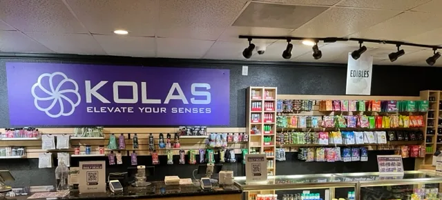 The counter at KOLAS Florin Perkins under a large purple KOLAS sign, with product walls behind it